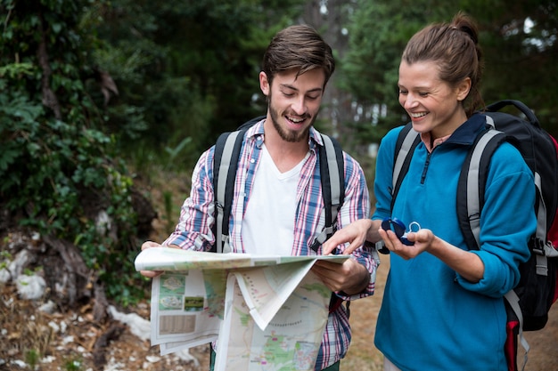 Hiker couple looking at map and compass