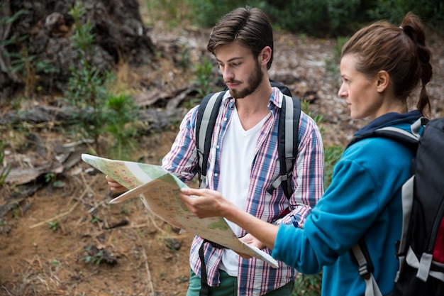 Hiker couple looking at map and compass