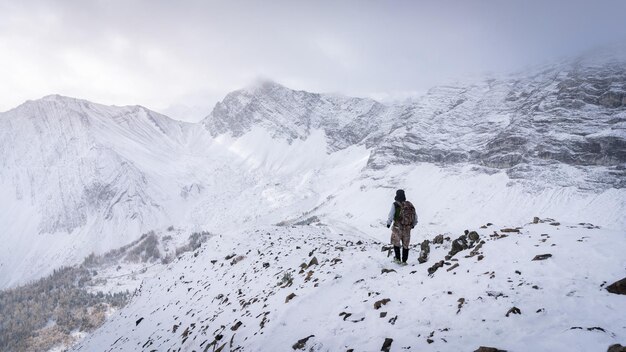Hiker descending from the mountain during winter narrow shot Kananaskis Canada