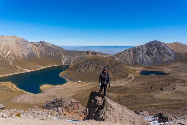 Hiker girl looking at the landscape panorama, mountain peaks and crater of nevado de toluca volcano in mexico