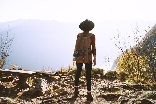 Девушка-путешественник с рюкзаком на вершине горы Женщина наслаждается отдыхом на открытом воздухе во время осеннего сезона