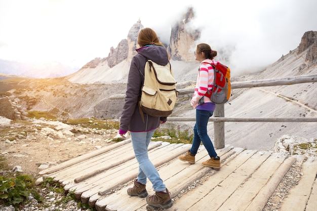 Hiker girls are walking along the trail at the  Tre Cime di Lavaredo. Dolomites, Italy.