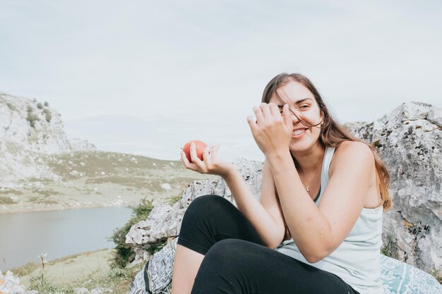 Hiker having a snack eat apple in the mountains, long trail rest, hiking activity, leisure and nature sport. Resting during the route in the lakes. Healthy life style with copy space for text