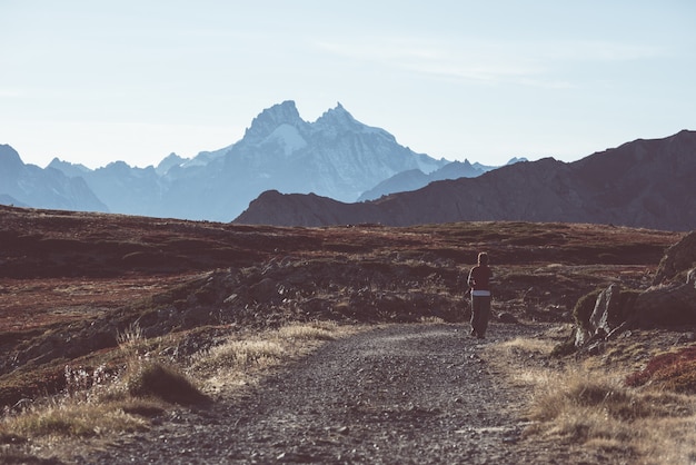 Hiker in high altitude rocky mountain landscape. Summer adventures on the Italian French Alps,