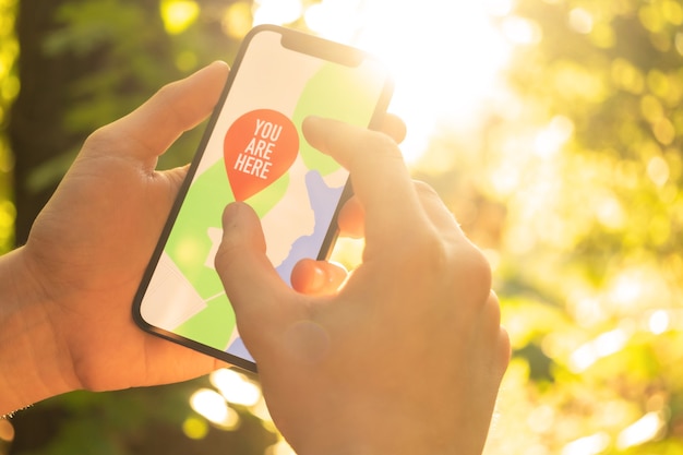 Hiker is using mobile phone for navigation in the forest