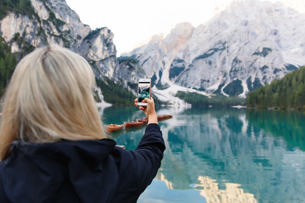 Hiker makes photo of beautiful landscape on smartphone