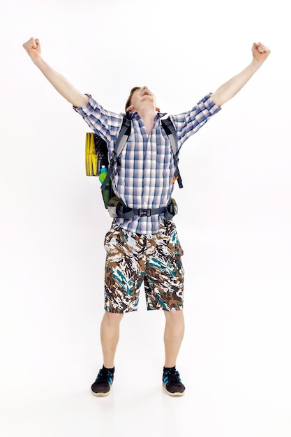 Hiker man with backpack rising arms in victory sign on the white background