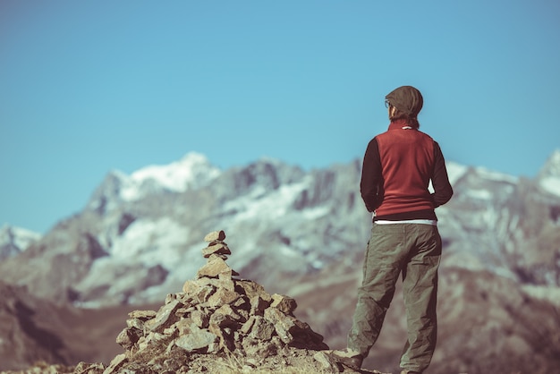 Hiker on mountain top looking at panoramic view, Massif des Ecrins National Park, the Alps