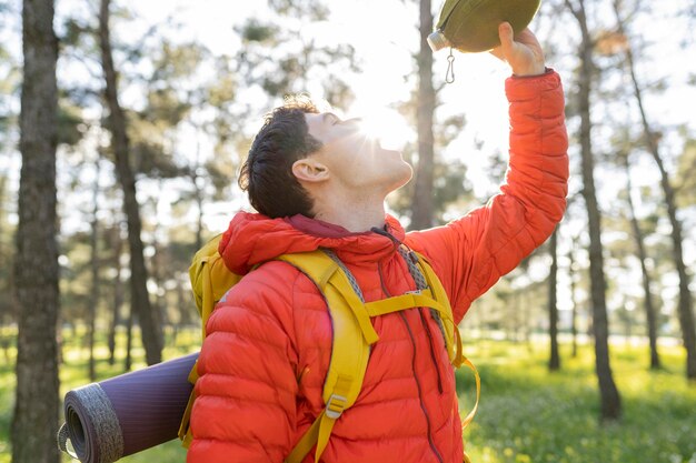Hiker in the mountains drinking water from his water bottle\
caucasian people people drink and nature concept