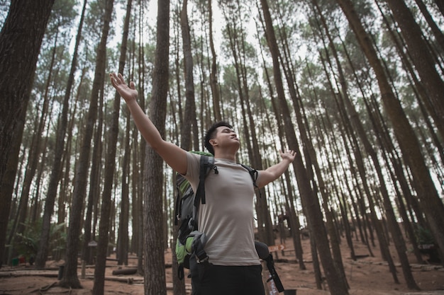 Hiker raise his arm relaxing in the forest