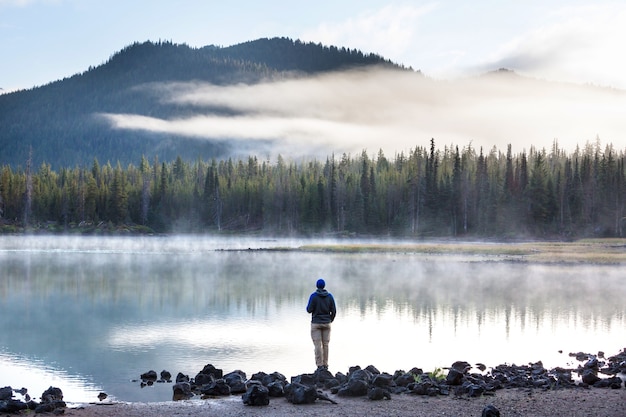 Hiker relaxing at serene mountain lake