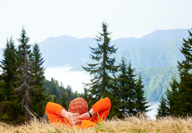 Hiker resting at viewpoint overlooking scenic mountains