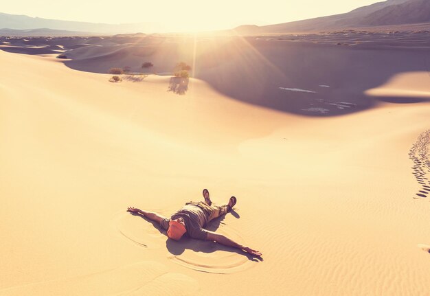 Foto escursionista nel deserto di sabbia. ora dell'alba.