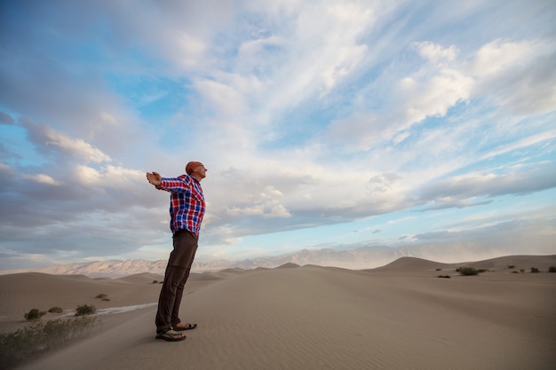 Hiker among sand dunes in the desert