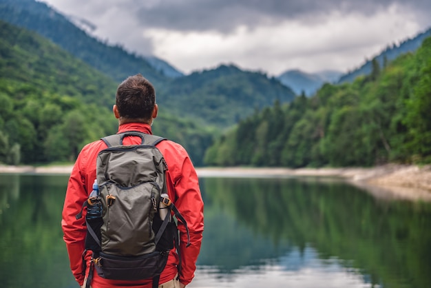 Hiker standing by the mountain lake