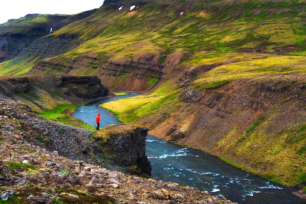 Hiker standing at the edge of the Laxa i Kjos river near Reykjavik in Iceland