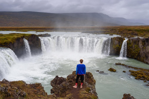 Hiker standing at the godafoss waterfall in iceland
