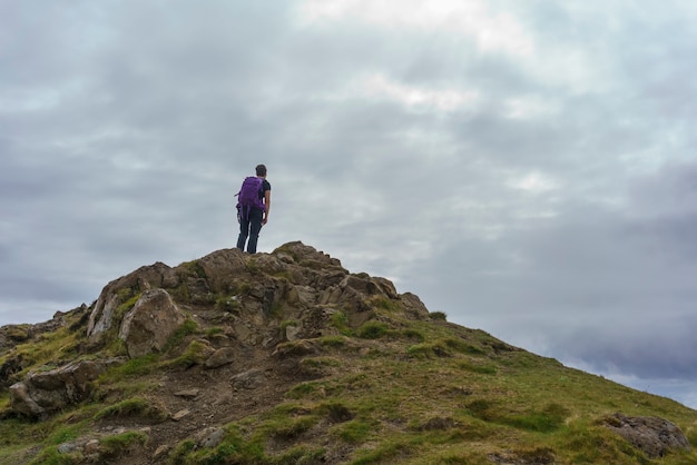 Escursionista in piedi sul picco di montagna presso il sentiero storr , isola di skye , scotland
