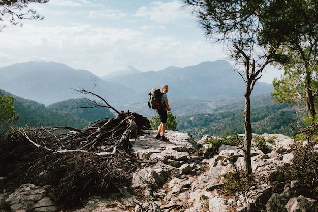 Hiker standing on rock against mountains