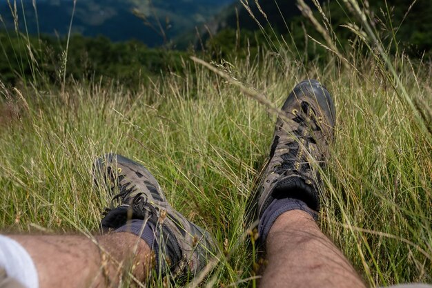 Escursionista in piedi sulla cima della montagna sullo sfondo del tramonto escursionista uomini escursionisti che vivono uno stile di vita sano e attivo