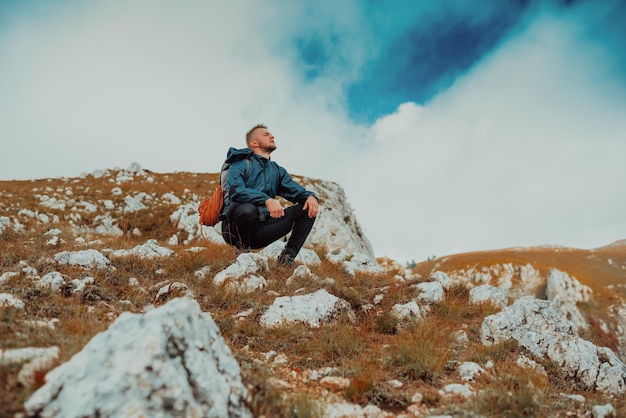 A hiker takes a break during the hiking route on the mountain