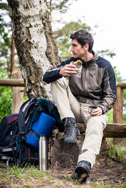 Hiker taking food break in shade of tree