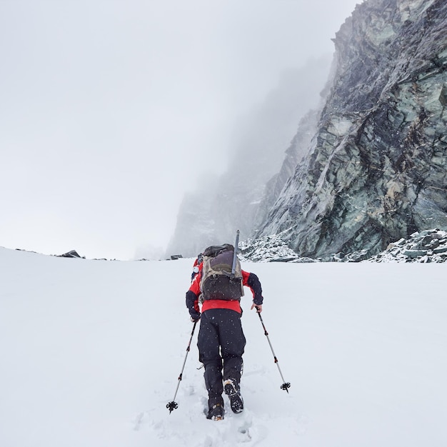 Hiker walking on snowy mountain path