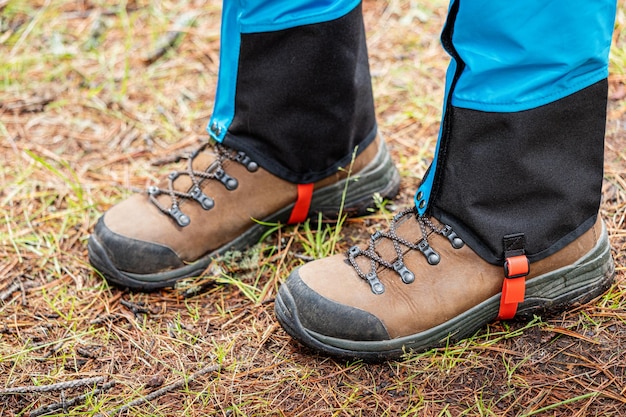 Путешественник носит гетры поверх треккинговых ботинок для защиты отводяных насекомых и холода. одежда и снаряжение для пеших прогулок икемпинга.