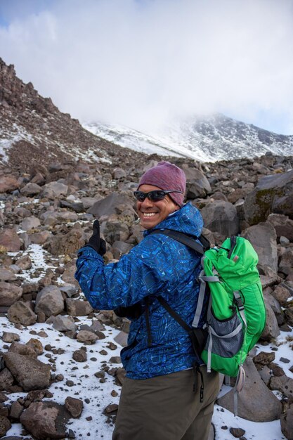 A hiker with a backpack climbing the Pico de Orizaba