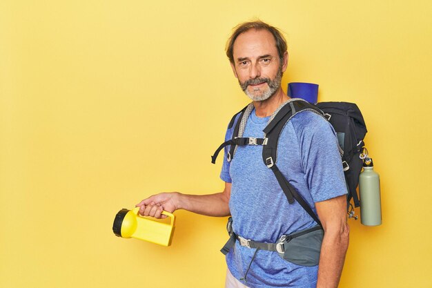 Hiker with backpack and lantern in studio