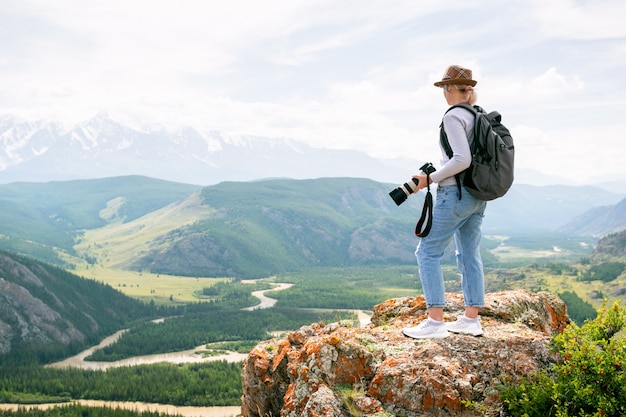 Hiker with backpacks enjoying valley view.