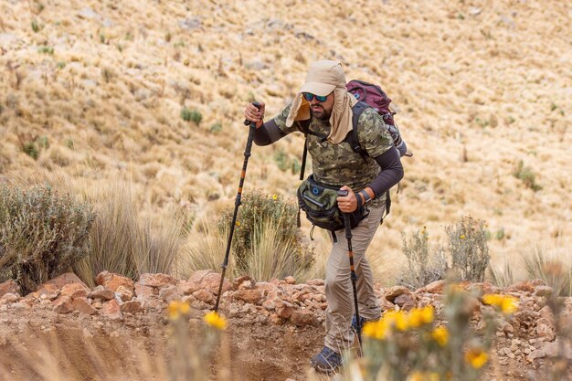 Photo a hiker with a green backpack and walking pols climbing the iztaccihuatl volcano