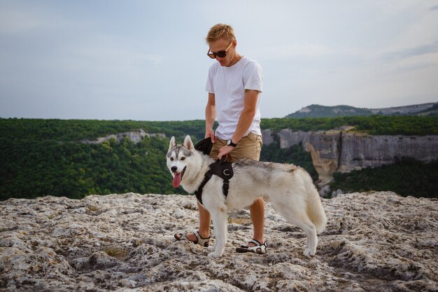 山の美しい景色を見てシベリアンハスキー犬とハイカー