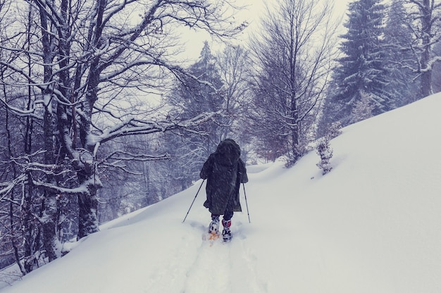 Hiker with snowshoes in winter