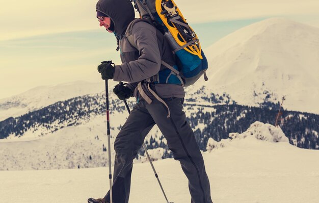 Hiker with snowshoes in winter