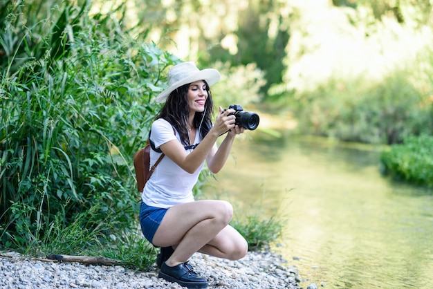 Foto donna della viandante che prende le fotografie con una macchina fotografica mirrorless