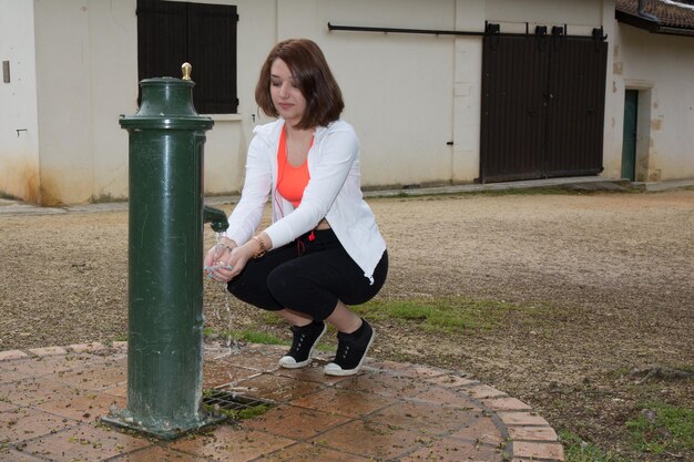 Foto donna della viandante che prende l'acqua nel parco dopo le vacanze escursionistiche