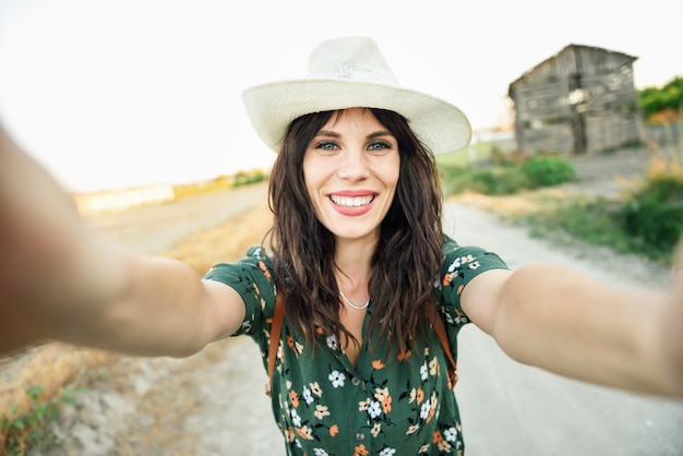 Hiker young woman taking a selfie photograph outdoors