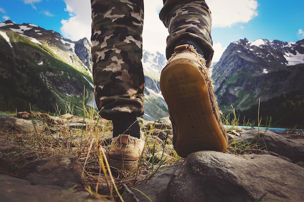 Photo hikers go along mountain ridge feet boots hiking traveler alone outdoor wild nature lifestyle travel extreme survival concept summer adventure vacations steps sole view from below