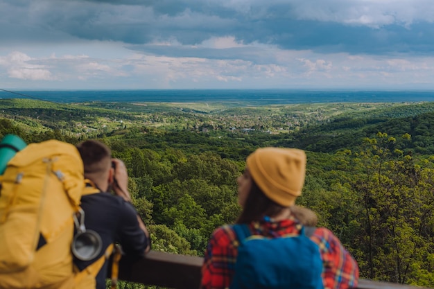 Hikers standing on a lookout while looking into the nature horizon