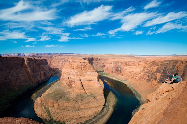 Hikers visiting horseshoe bend against sky