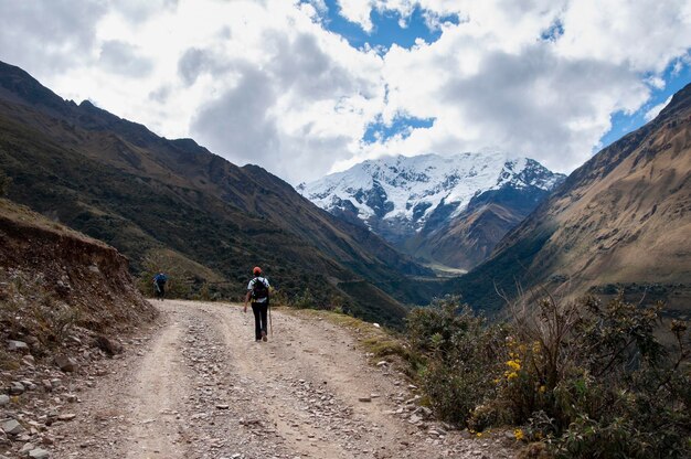 Photo hikers walking towards the big snowy mountain salkantay andes mountain range