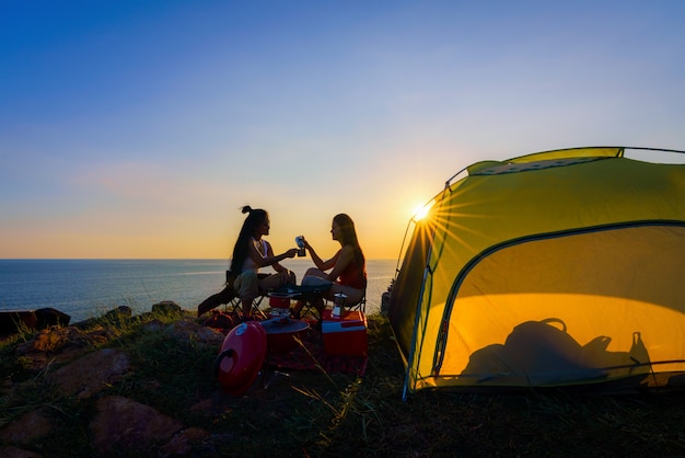 Hikers walking with backpack on a mountain at sunset. traveler going camping