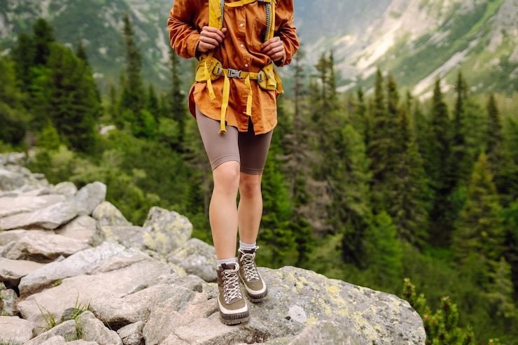 Photo hiking boot closeup of female legs in hiking boots on hiking trail on top of mountain outdoors