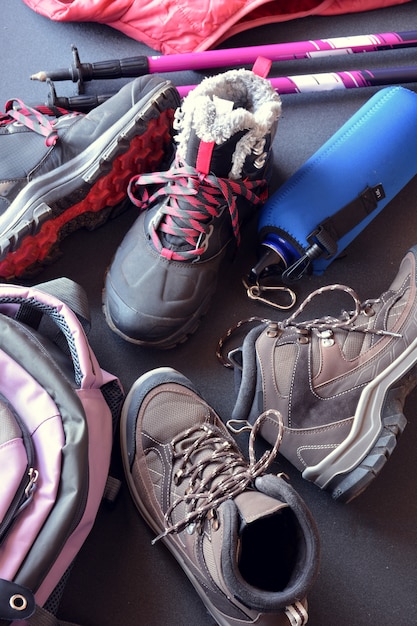 Hiking clothes for women and men, composed of boots, backpack, water bottle and walking sticks