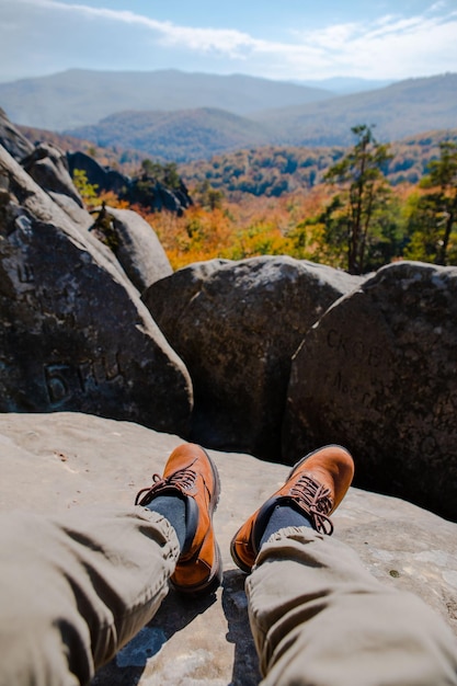 Hiking concept men legs in boots on the rock