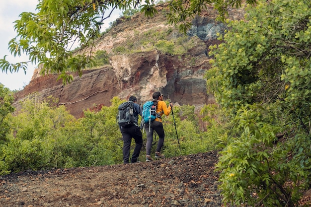 hiking couple in action mountain hiking with man and woman black and blue backpacks