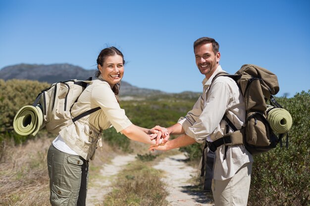 Hiking couple putting hands together on country trail