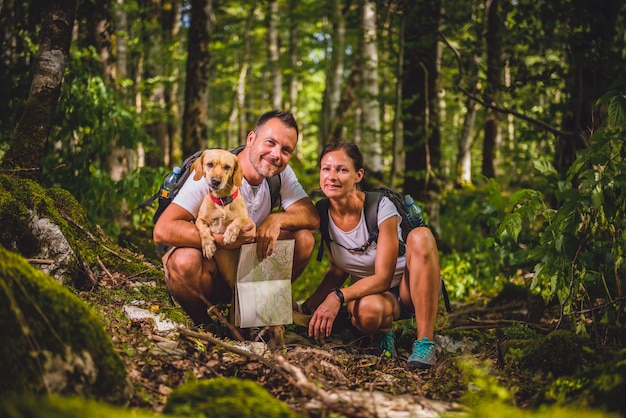 Hiking couple with dog posing in forest