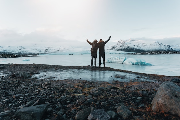 Escursionismo su un ghiacciaio in islanda, vista mozzafiato, il viaggiatore si erge su una pietra, i viaggiatori hanno raggiunto la loro destinazione, l'amicizia